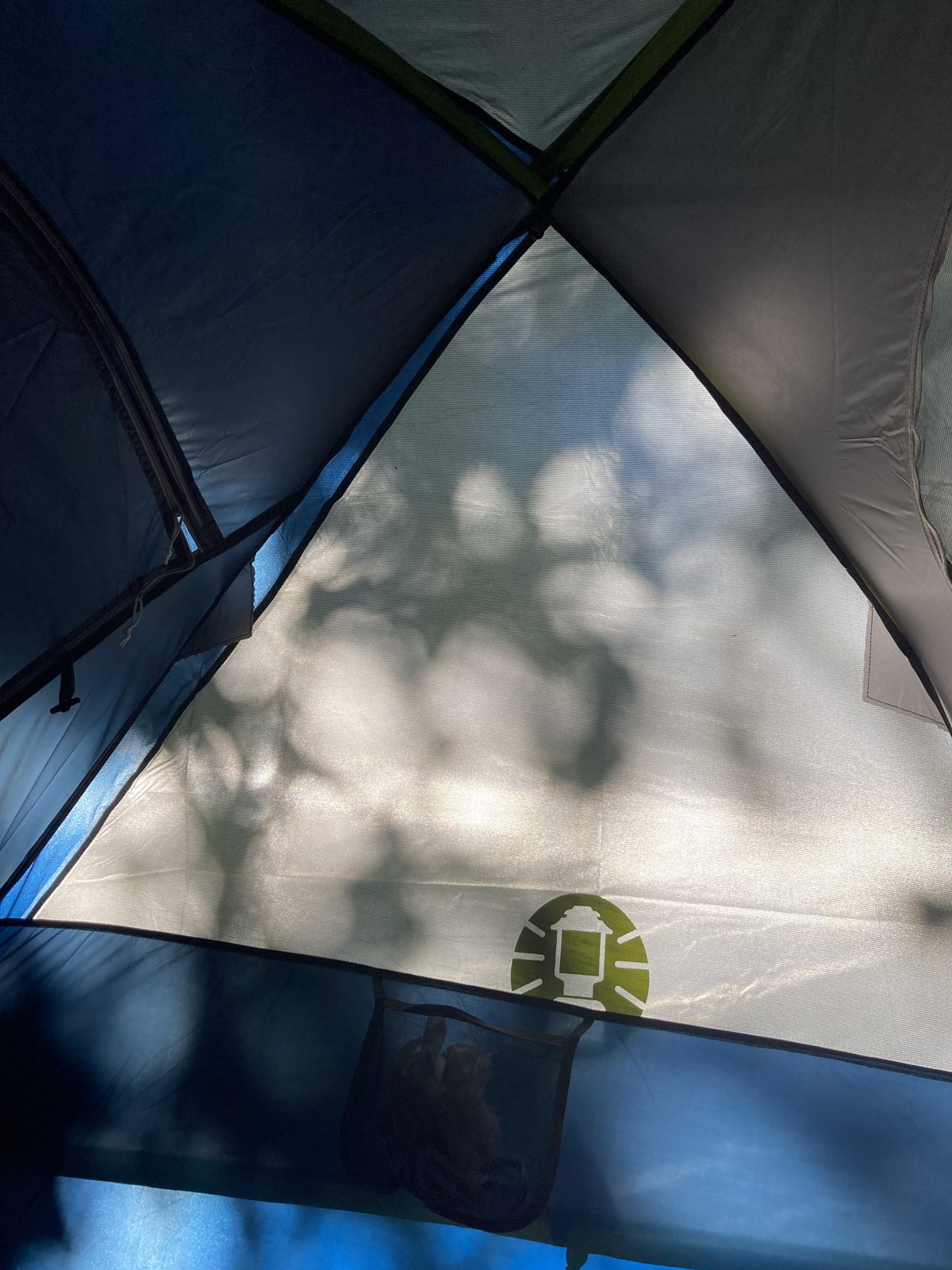 Morning light and leaf shadows on a tent wall while camping